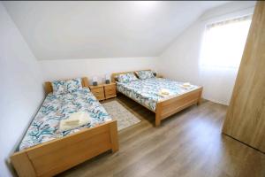 a bedroom with two beds and a window at Apartman Luki in Soko Banja