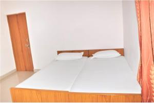 - un lit avec 2 oreillers blancs dans l'établissement Goroomgo Teerth Guest House Varanasi Near Temple and Ganga Ghat, à Varanasi