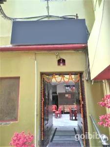 - l'entrée d'un bâtiment avec des tables et des chaises rouges dans l'établissement Goroomgo Teerth Guest House Varanasi Near Temple and Ganga Ghat, à Varanasi