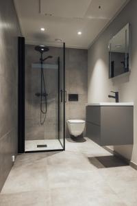 a bathroom with a glass shower and a toilet at Highland Lodge Fjellandsby in Geilo