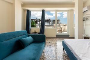 a living room with a blue couch and a large window at ATHENS COMMERCIAL in Athens