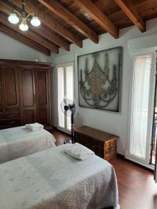 a bedroom with two beds and a painting on the wall at Casa O Cobo in Padrón