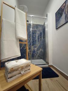a room with a glass shower and a wooden table at La casa sui tetti in Catania