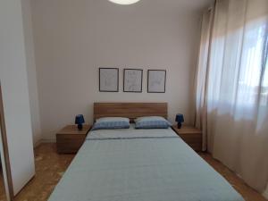 a white bedroom with two beds and a window at La casa sui tetti in Catania