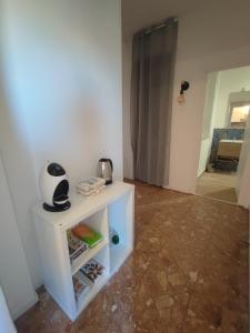 a small white cabinet in a room with a door at La casa sui tetti in Catania