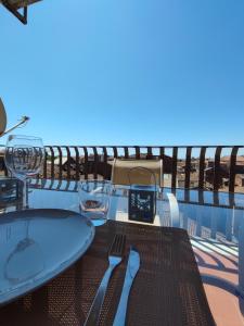 a table on a balcony with a view of the ocean at La casa sui tetti in Catania