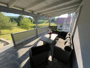 a patio with a couch and a table on a balcony at Rooms Mirabella in Rakovica