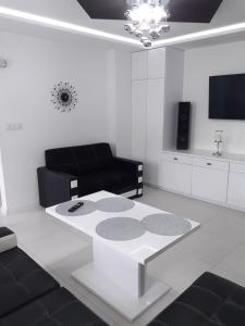 Sala de estar blanca con sofá y mesa en Apartament Pegaz, en Gniezno