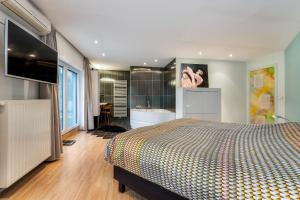 een slaapkamer met een bed en een badkamer met een bad bij Huis @ Sint Kruis in Brugge