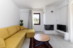 a living room with a yellow couch and a table at Malathro Olympus Guest House in Díon