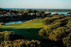 an aerial view of a golf course with the ocean at casita en la playa in El Rompido