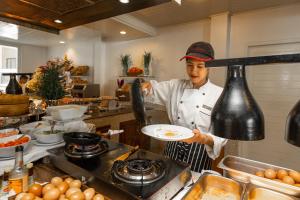 a chef is preparing food in a kitchen at Centara Kata Resort Phuket in Kata Beach