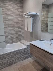 ein Bad mit einer Badewanne, einem Waschbecken und einer Dusche in der Unterkunft HOTEL AMBEILLE in Collioure