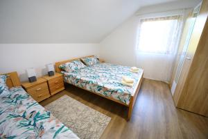 a small bedroom with a bed and a window at Apartman Luki in Soko Banja