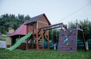 un parco giochi con una casa e uno scivolo di Casa Mihaela a Câmpulung Moldovenesc