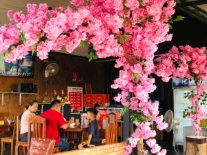 un arbre recouvert de fleurs roses dans un restaurant dans l'établissement กอบสุข รีสอร์ท2 k02, à Ban Ton Liang