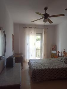 a bedroom with a bed and a ceiling fan at Mar1 in Carboneras