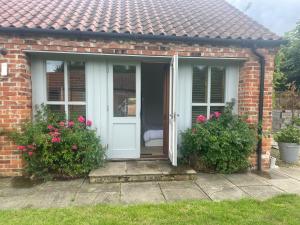 a red brick house with a white door and flowers at The Jasmine Suite in Newark upon Trent