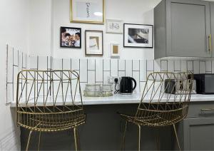 a kitchen with a counter with two bar stools at Bella-Ruiz Home for Your Perfect Staycation in London