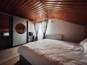 a bedroom with a large bed with a wooden ceiling at Hypnotic Villa Pitesti in Piteşti