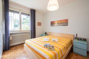 een slaapkamer met een bed met een gele en oranje gestreepte deken bij Pazzallo Panoramica - Happy Rentals in Lugano