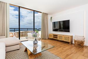 a living room with a couch and a tv at Luxury Beach Views 2BR House - Private Parking in Arrecife
