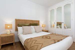 1 dormitorio con 1 cama blanca grande y 2 lámparas en Luxury Beach Views 2BR House - Private Parking en Arrecife