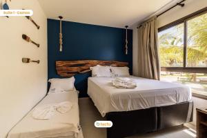 Lindo térreo espaçoso no VG Sun Cumbuco por Tactu في كومبوكو: غرفة نوم بسريرين وجدار ازرق