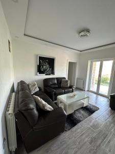 a living room with a leather couch and a coffee table at Vila Jovanka in Tivat