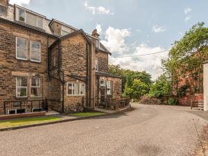 an empty street in front of a brick house at Pass the Keys Hidden Gem Near Roundhay Park in Leeds