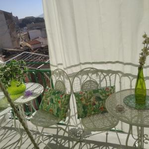 2 mesas y sillas en un balcón con flores en Casa Amari alla Zisa HOSTEL, en Palermo