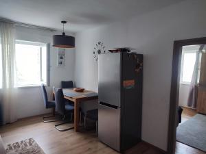 eine Küche mit einem Kühlschrank und einem Tisch mit Stühlen in der Unterkunft Apartment Salve & Sonne in Hopfgarten im Brixental