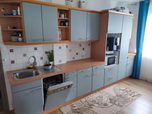 eine Küche mit weißen Schränken und einem Waschbecken in der Unterkunft Apartment Salve & Sonne in Hopfgarten im Brixental