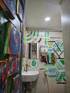 a bathroom with a sink and paintings on the wall at Green Cocoon in Ho Chi Minh City
