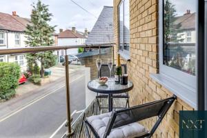 a balcony with a table with a bottle of wine at Apartment in Central Watford in Watford