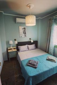 a bedroom with a bed and a table and a lamp at Elpida Suites in Nea Irakleia