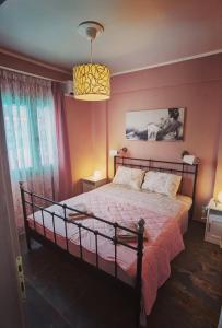 a bedroom with a large bed with pink walls at Elpida Suites in Nea Irakleia