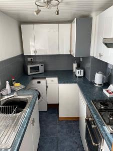cocina con armarios blancos y encimera en Lovely 2 bedroom Apartment with Free Parking en Borrowash