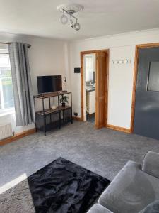 uma sala de estar com um sofá e uma televisão de ecrã plano em Lovely 2 bedroom Apartment with Free Parking em Borrowash