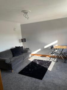 sala de estar con sofá negro y mesa en Lovely 2 bedroom Apartment with Free Parking, en Borrowash