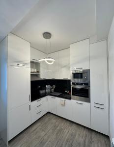 a white kitchen with white cabinets and appliances at Vila Jovanka in Tivat