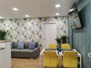 多瑙新城Kossuth 10的客厅里有一张沙发、一张桌子和几把椅子。