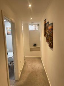 a hallway with two paintings on the wall and a window at Lovely one bed Fitzrovia/soho in London