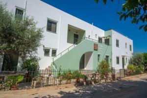 a white and green building with a fence at Xenios Zeus Apartments in Kissamos