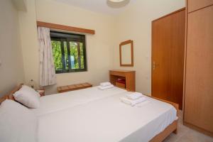 a bedroom with two white beds and a window at Xenios Zeus Apartments in Kissamos
