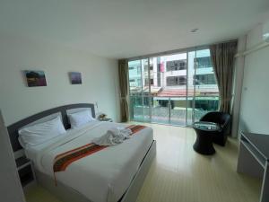 a hotel room with a bed and a large window at Toto Residence in Ao Nang Beach