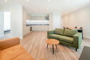 ein Wohnzimmer mit einem Sofa und einem Tisch in der Unterkunft Modern Apartments in Brentford 2 minutes walk from Kew Bridge in Brentford