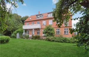 a large brick house with a lawn in front of it at 2 Bedroom Pet Friendly Apartment In Svaneke in Svaneke