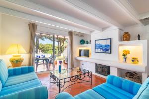 a living room with blue couches and a fireplace at The Old Village, Prestige and Solar by Village 4U in Vilamoura