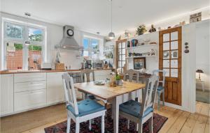 a kitchen with a wooden table and chairs at 2 Bedroom Pet Friendly Apartment In Svaneke in Svaneke